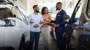 A couple buying a car from a car salesman